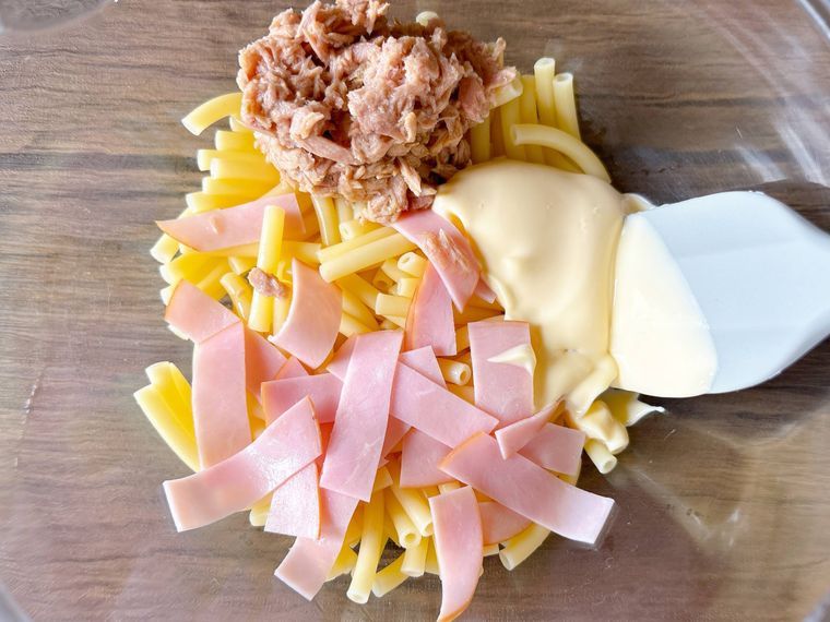 マカロニ、ハム、ツナ缶、マヨネーズ、穀物酢を混ぜる様子