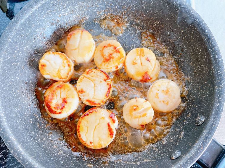 ホタテのバター焼きにしょうゆを絡める様子