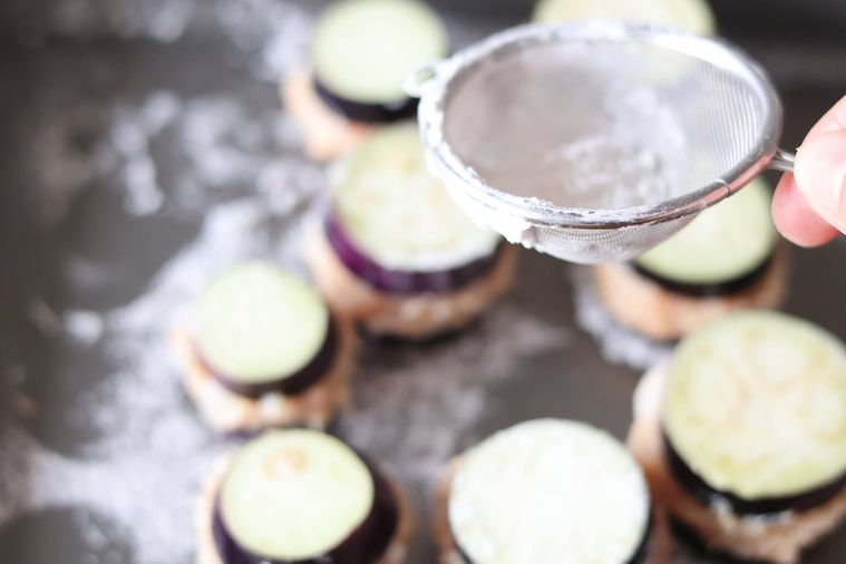 肉だねを挟んだなすに片栗粉を振っている