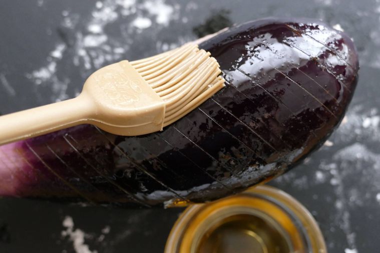 なすの表面に刷毛でごま油を塗る様子