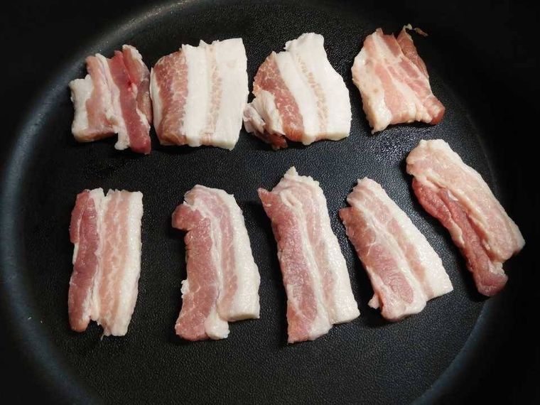 豚バラ肉をフライパンで焼いている