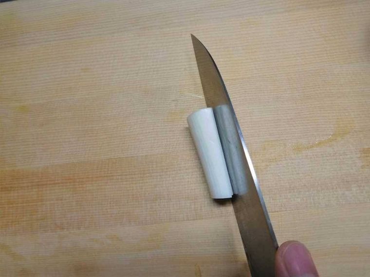 長ねぎに包丁で切り込みを入れている様子
