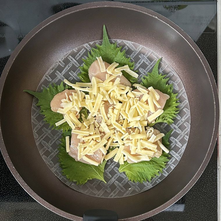 フライパンに重ねられたライスペーパー、鶏ささみ、チーズ、大葉