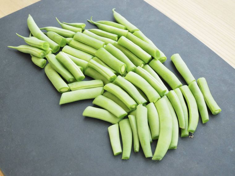 黒いまな板に置いたカットしたいんげん