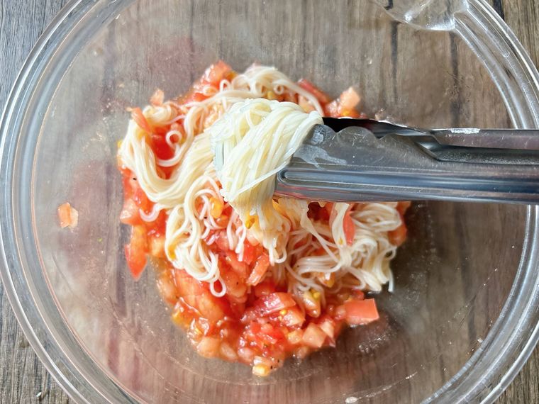 トマトだれにそうめんを和える様子