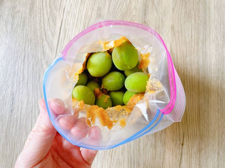 ジッパー袋に青梅を入れる様子