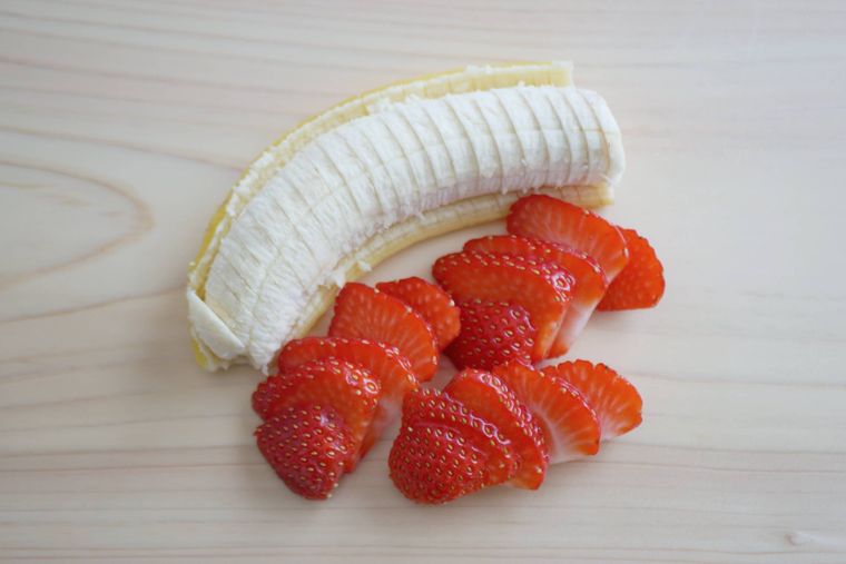 木製のまな板の上にのったバナナといちご