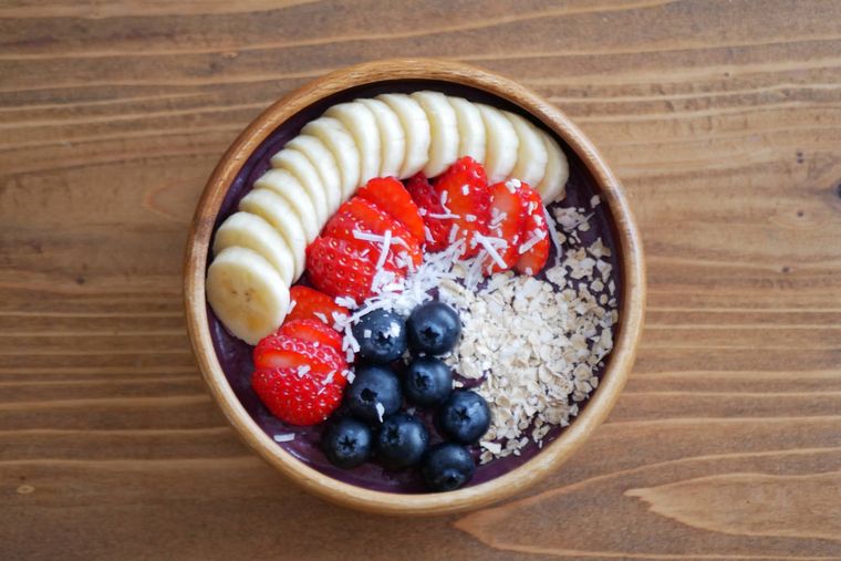 木の器に入ったフルーツたっぷりのアサイーボウル