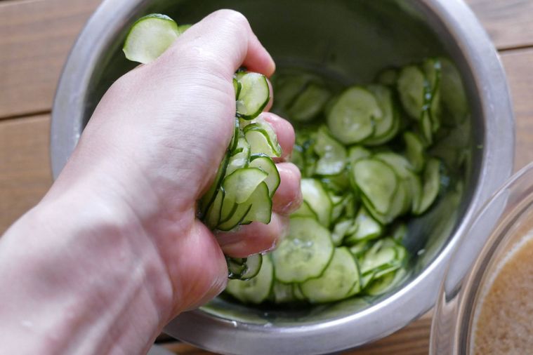 塩もみしたきゅうりを手で握って絞る様子