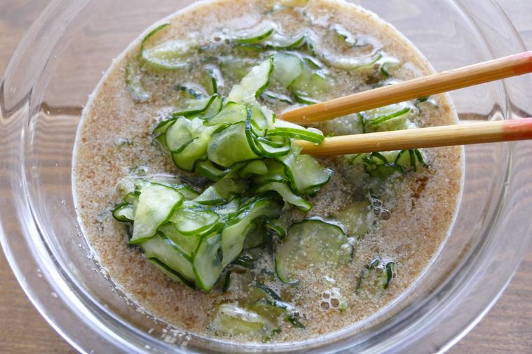 きゅうりと調味料を箸で混ぜる様子