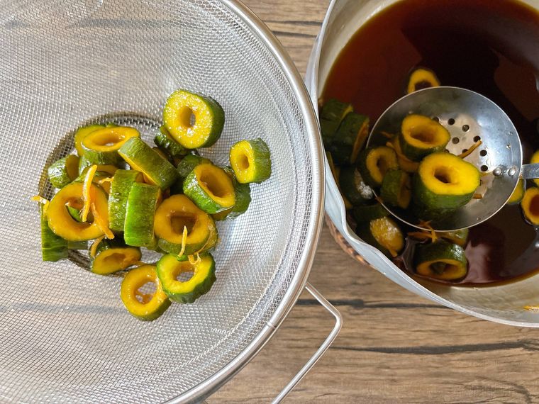 漬け汁からきゅうりとしょうがをザルにあげる様子