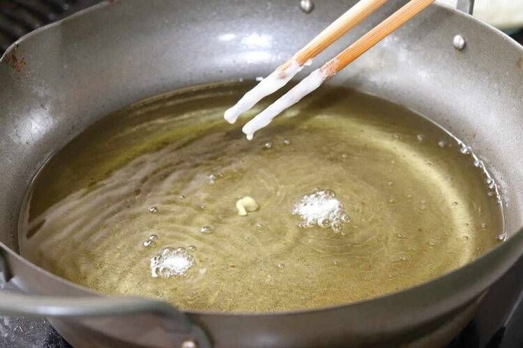 油が入った天ぷら鍋と衣がついた菜ばし