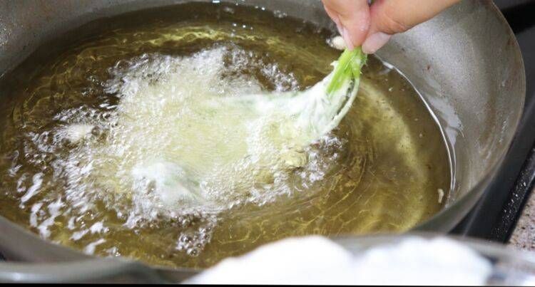 春菊を天ぷら鍋に入れている画像