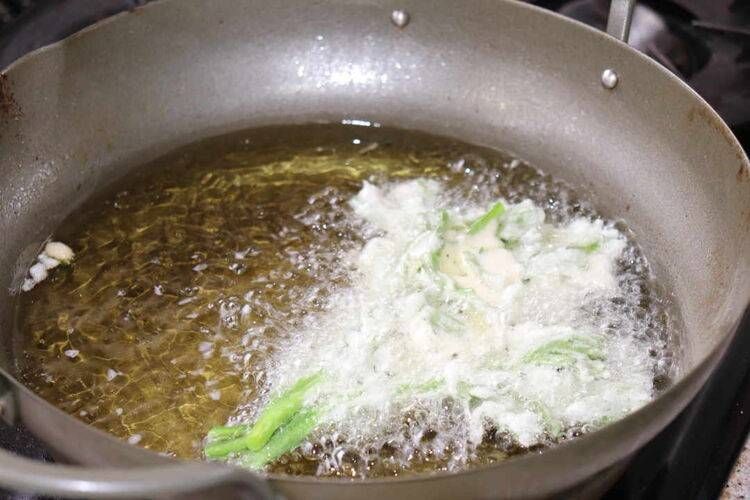 天ぷら鍋に入っている春菊の天ぷら