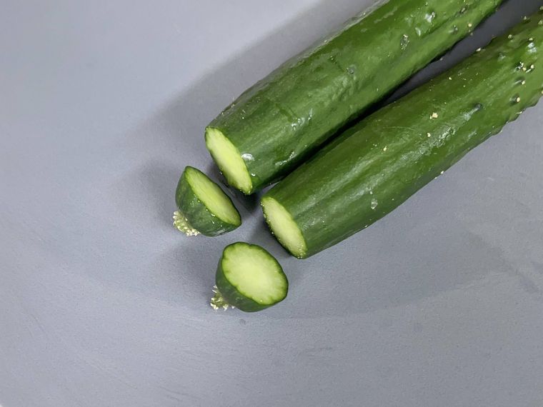 グレーのまな板にのったきゅうりときゅうりのヘタ