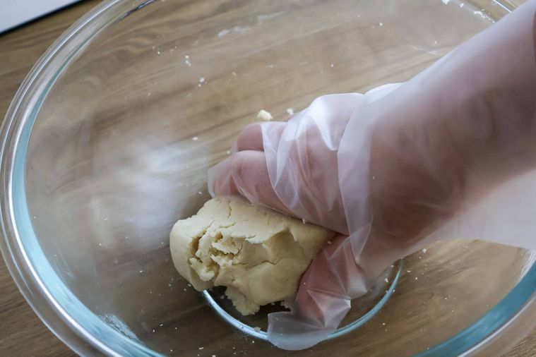 ボウルの中で手で生地を掴んでいる