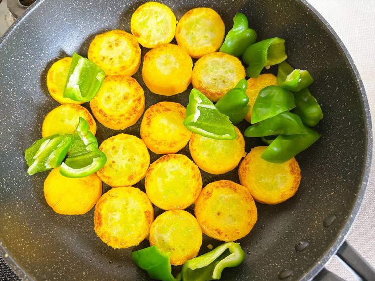 ピーマンと黄色ズッキーニを炒める様子