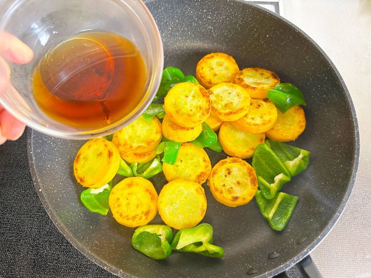 黄色ズッキーニとピーマンに調味料をまわしかける様子