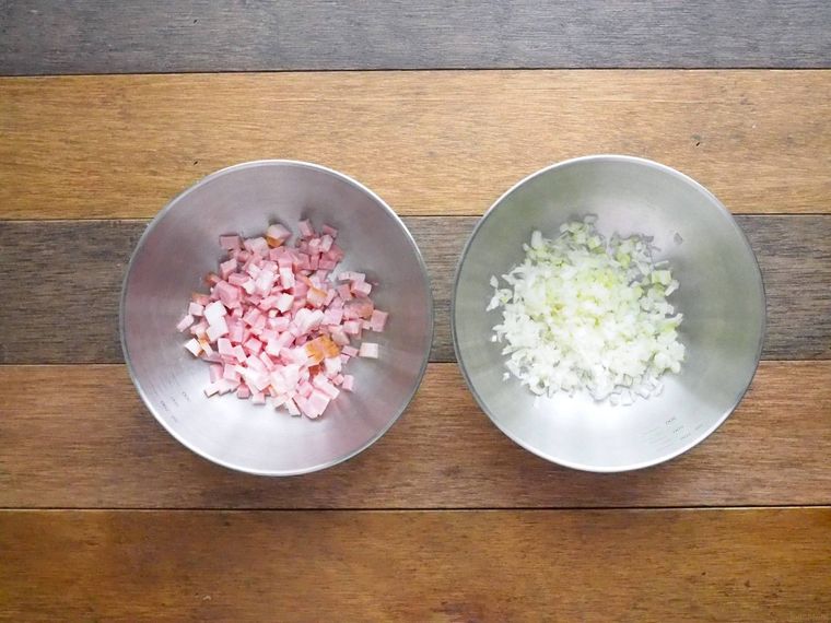 銀のボウルに入れたみじん切りにしたベーコンと長ねぎ