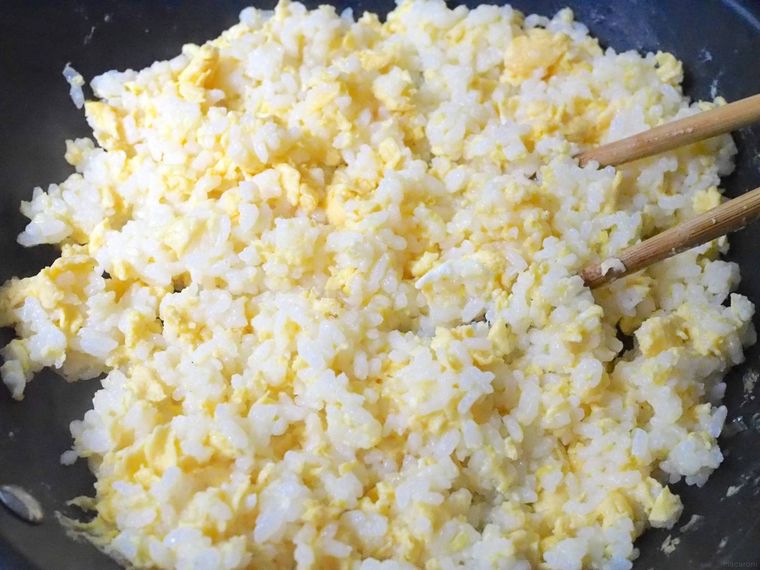 菜箸でチャーハンを炒めている様子