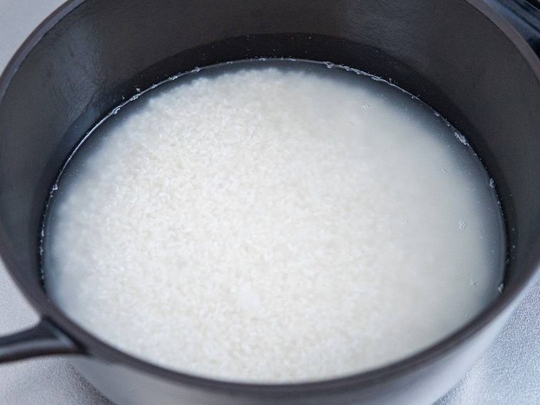 黒いホーロー鍋に入った米と水