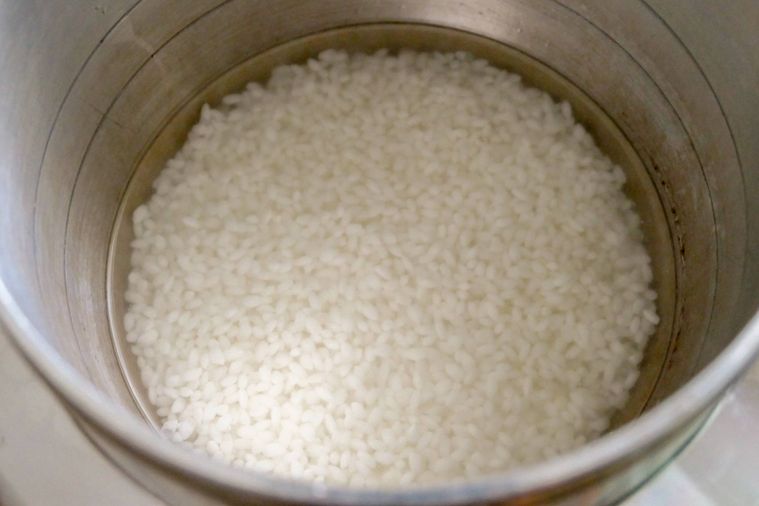 米が入っている釜に水を注ぐ様子