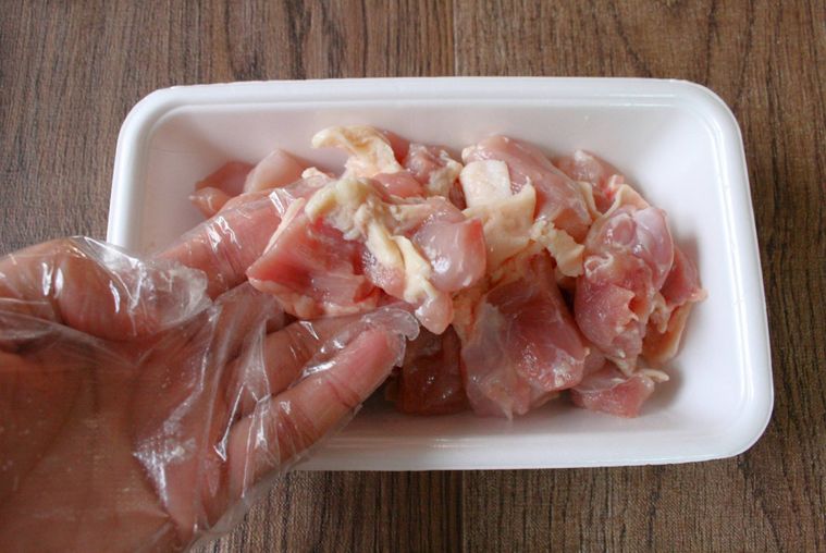 ひと口大に切った鶏もも肉をひとつ手に持っている様子