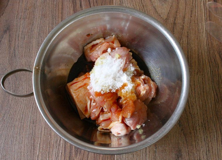 銀色のボウルに鶏もも肉と漬けだれの調味料を入れた様子