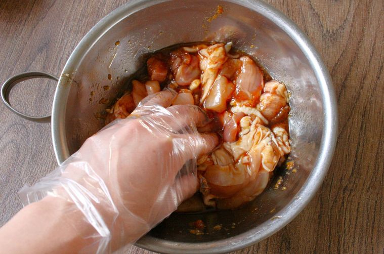 鶏もも肉と調味料を揉み込んでいる様子
