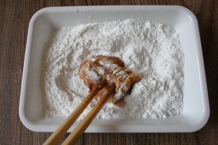 鶏もも肉に粉をまぶしている様子