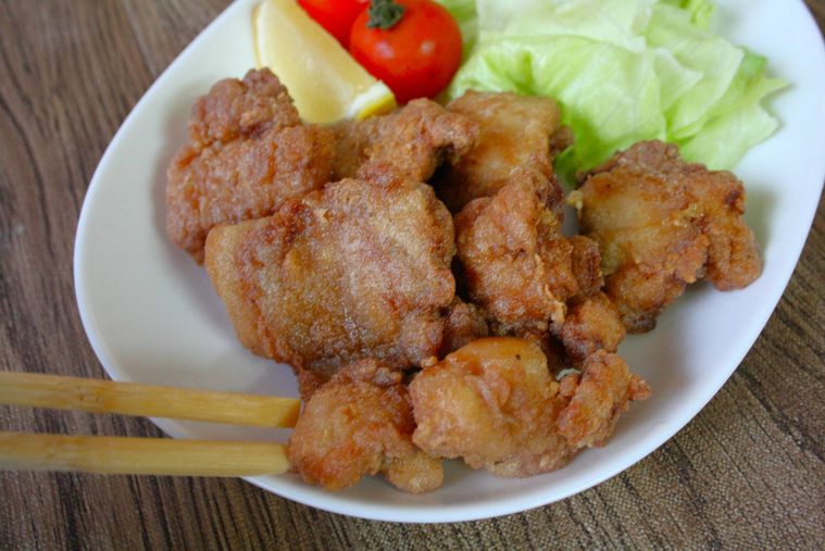 白い皿にモチコチキンを盛りつけている様子
