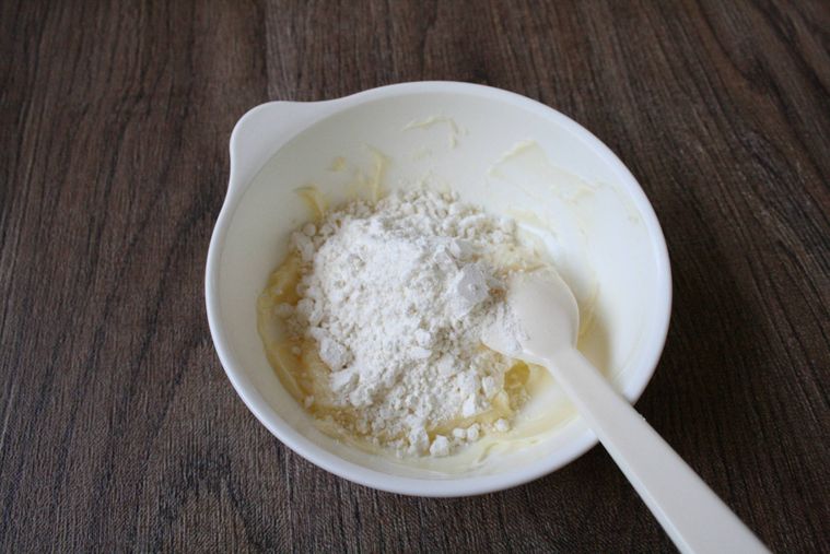 白い器でバターと薄力粉を混ぜている様子