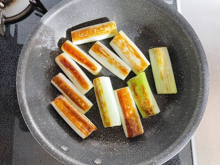 フライパンに入った、焦げ目が付いた長ねぎ