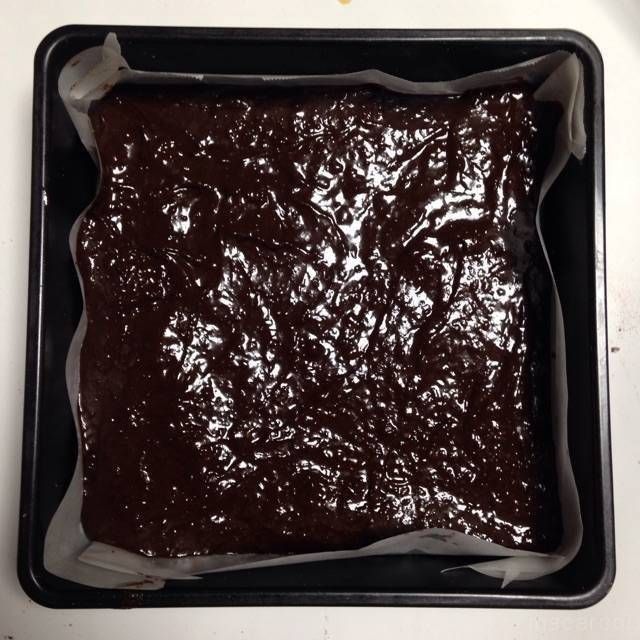 ブラウニー生地を流した、クッキングシートを敷いた四角い型