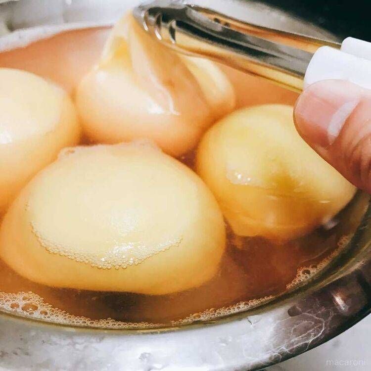 ボウルの中で桃の皮を剥いている様子