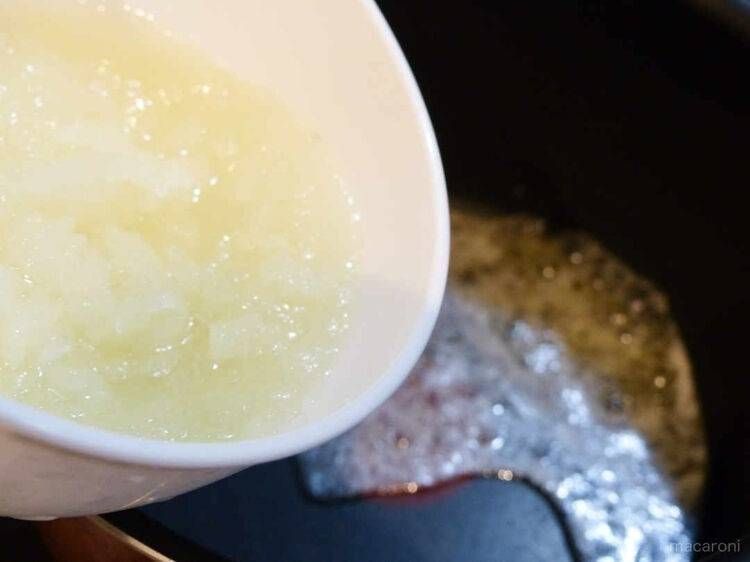 鍋に玉ねぎを加えている様子