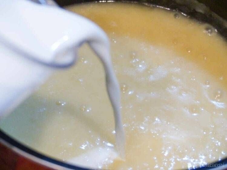 じゃがいもポタージュの材料が入った鍋に牛乳を加えている様子