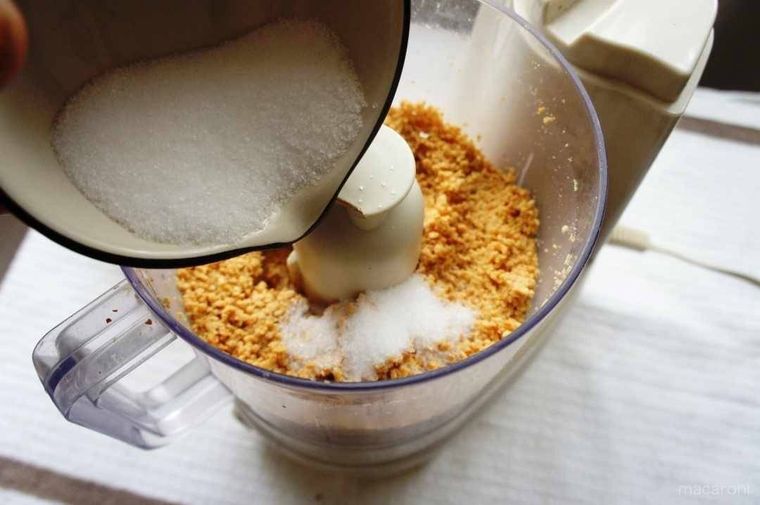 撹拌されたピーナッツに砂糖を加える様子