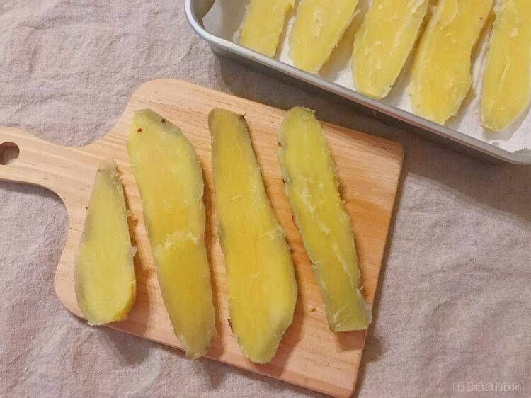 木製のカッティングボードに並んだカットされたさつまいも