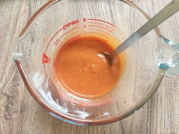 計量カップに入ったプデチゲのタレをスプーンで混ぜている様子