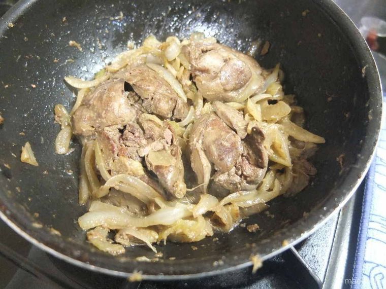 フライパンの中の加熱した鶏レバーと玉ねぎ