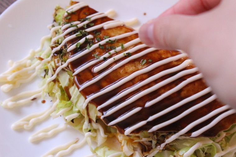 キャベツ焼きに青のりをかけている様子