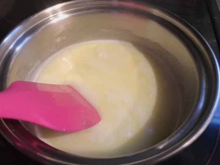 生キャラメルの材料が入った鍋をゴムベラで混ぜながら煮詰め、少しとろみが付いた様子