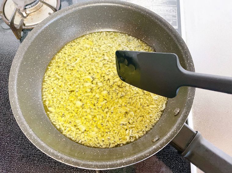 オリーブオイルとにんにくを炒める様子