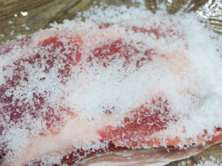 豚肉に塩をすり込んでいる様子