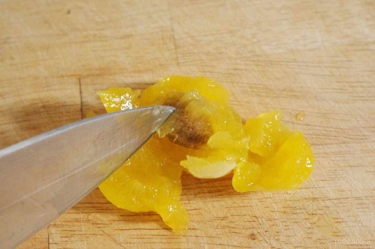 包丁でゆでた梅から種を取り出す