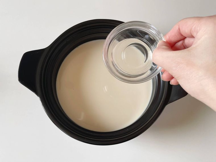豆乳が入った土鍋ににがりを入れる