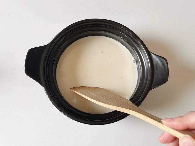 土鍋に入った豆乳とにがりを混ぜる様子