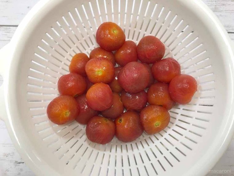皮をむいたミニトマトをざるにあける