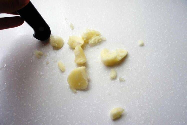 にんにくを包丁の柄で潰しています。